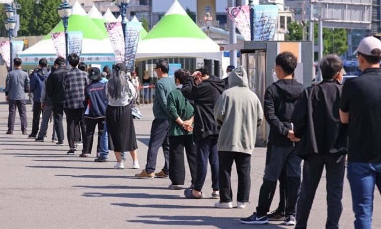 Personas haciendo cola para tomarse la prueba de COVID-19 en Seúl
